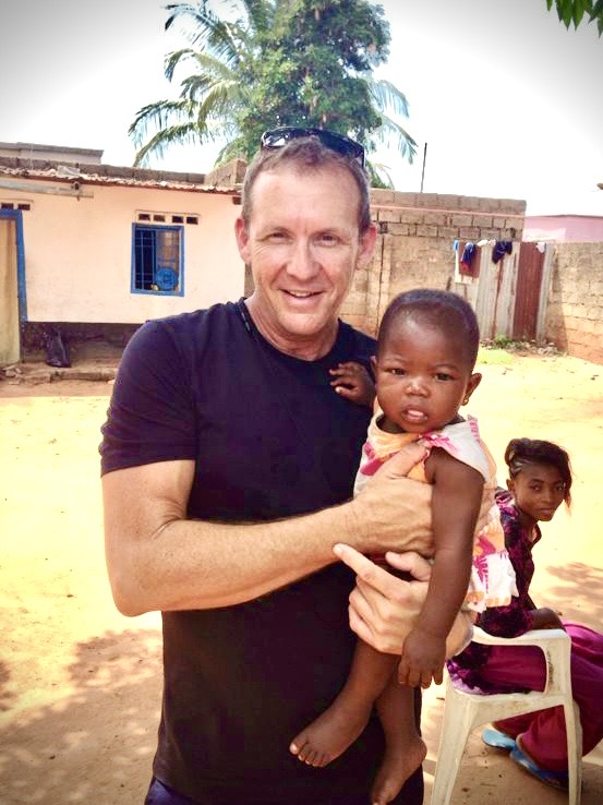 Scott van Iperen holding a child during time in Africa