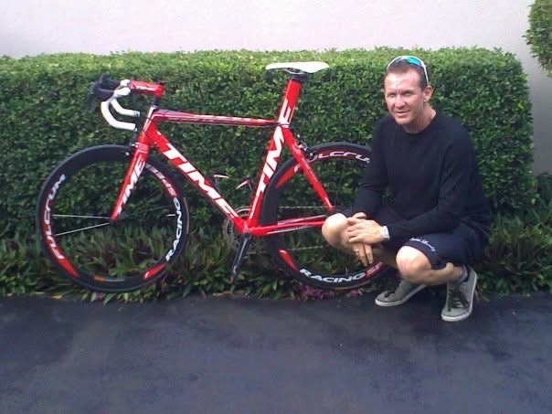Scott van Iperen beside a red road bicycle